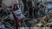 A Palestinian child takes a bag of flour from a destroyed house after an Israeli air strike, in the Swedish village (Al-Ezbah). The house belongs to the Abu Salima Najm family at least five were killed and dozens injured, near the Egyptian border on the seashore in the city of Rafah in the southern Gaza Strip.