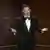 Jimmy Kimmel gesturing with his hand, looking toward camera while hosting the Academy Awards in 2024