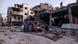 People sit around a table in rubble People sit around a table in rubble