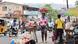 People on the streets in Freetown. A woman carries apples on her head.