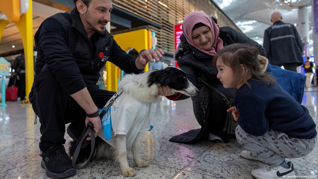 İstanbul Havalimanı'nda bir köpek, havaalanı çalışanı, çocuk ve annesi