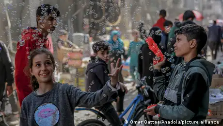 Children in Deir al-Balah in the Gaza Strip play carefree with soap bubbles.