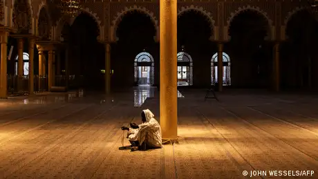 A devout Senegalese man sits in silence on the eve of Ramadan, in an almost deserted mosque