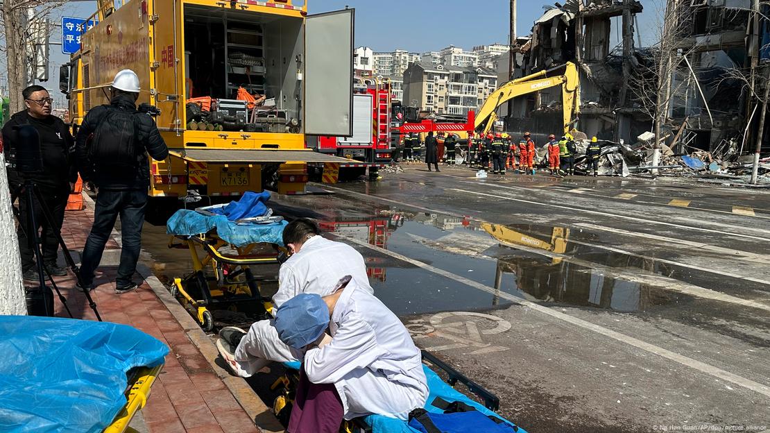 Los paramédicos esperan en el lugar de una explosión mientras los rescatistas continuaban buscando víctimas entre los escombros. Los paramédicos esperan en el lugar de una explosión mientras los rescatistas continuaban buscando víctimas entre los escombros.