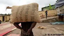 People carry bags of cocoa at a cocoa exporter's in Abidjan, on July 3, 2019. In June key producers Ivory Coast and Ghana threatened to stop selling their production to buyers unwilling to meet a minimum price of $2,600 per tonne.
The two African nations -- which together account for 60 percent of the world's cocoa production -- want to end a situation where cocoa producers make only $6 billion in a global chocolate market worth around $100 billion. (Photo by Sia KAMBOU / AFP) (Photo by SIA KAMBOU/AFP via Getty Images)