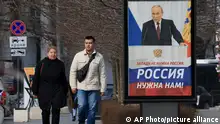 06/03/2024 *** FILE - People walk past a billboard with an image of Russian President Vladimir Putin and words reading The West doesn't need Russia, we need Russia! in a street in Sevastopol, Crimea, on March 6, 2024. Russian President Vladimir Putin Thursday called on people in Ukraine's occupied regions to vote, telling them and Russians that participation in the elections is manifestation of patriotic feeling, (AP Photo, File)
