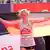 Marathonläuferin Fabienne Königstein jubelt mit Deutschlandfahne im Ziel des Hamburg-Marathons