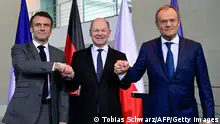 15/03/2024 *** (L-R) French President Emmanuel Macron, German Chancellor Olaf Scholz and Polish Prime Minister Donald Tusk join hands at a press conference at the Chancellery in Berlin on March 15, 2024. The three heads of state came together for a meeting of the so-called Weimar T
