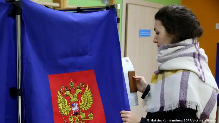 俄罗斯总统选举周日结束，图为一名女子在圣彼得堡参加投票。