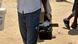 A man in Angola holds a large TV camera in his hand.