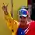 Venezuela I Nicolas Maduro in Trainingskleidung in den venezolanischen Staatsfarben strahlt und reckt beide Hände zum Victory-Zeichen geformt in die Höhe (29.02.2024)