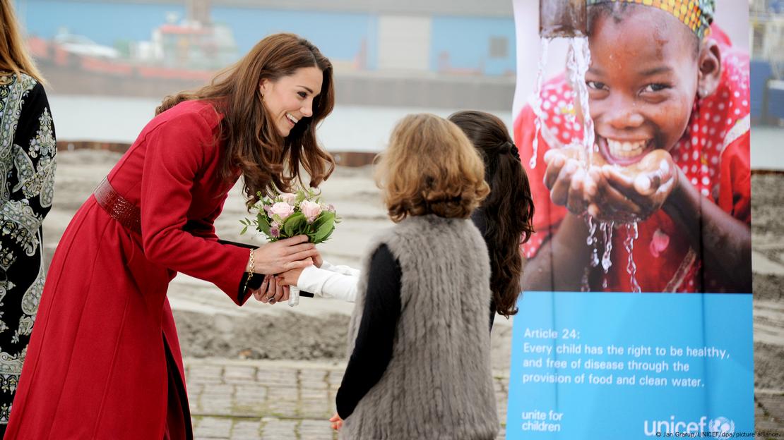 Princess Catherine smiles as she receives flowers from two local girls on her arrival at UNICEF's Supply Division, Copenhagen