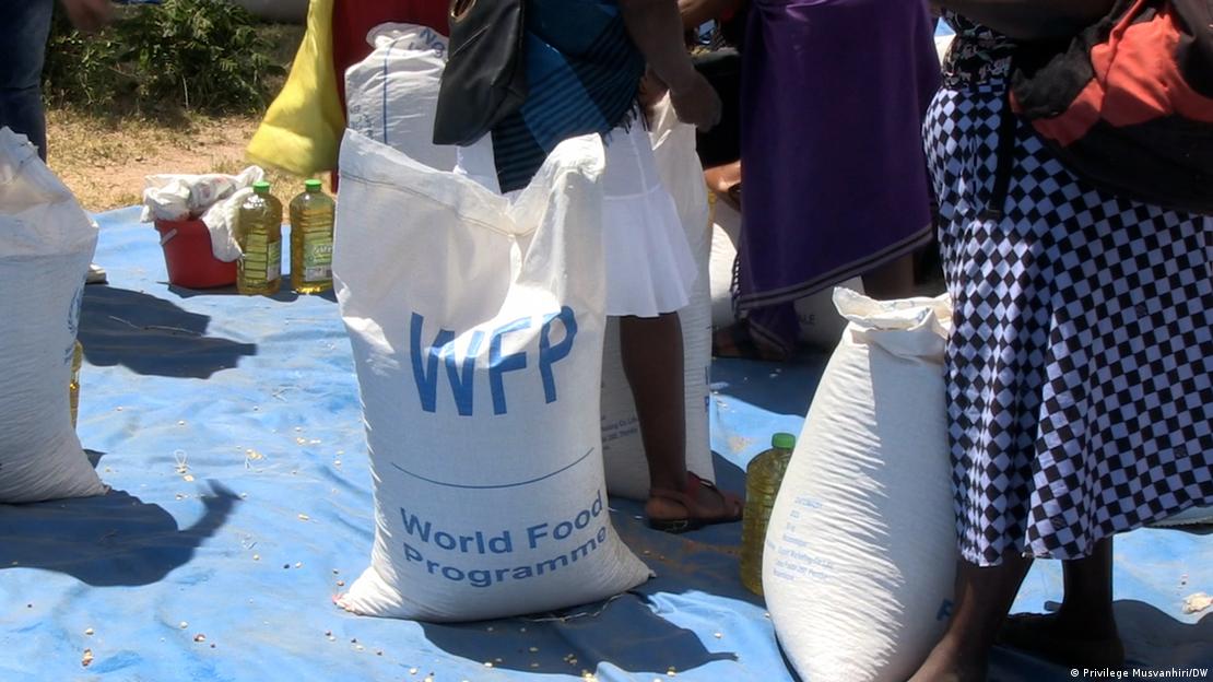 Saco de comida do World Food Program, com pessoas em volta