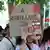 Mujer eleva una pancarta durante una protesta que pone: "A romper lazos con Israhell"