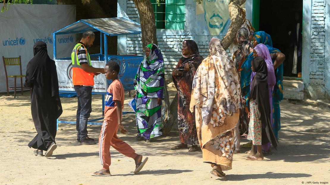 Des Soudanais déplacés parlent avec un travailleur humanitaire lors d'une livraison d'aide humanitaire dans une école où des familles se sont réfugiées Des Soudanais déplacés parlent avec un travailleur humanitaire lors d'une livraison d'aide humanitaire dans une école où des familles se sont réfugiées