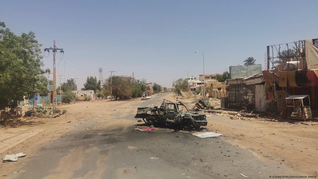 Carro destruído em estrada de terra deserta