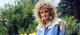 Bonnie Tyler in 1980s style, in a flowery garden.