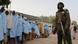 A soldier stands next to a group of girls who were previously kidnapped from their boarding school in northern Nigeria. A soldier stands next to a group of girls who were previously kidnapped from their boarding school in northern Nigeria.