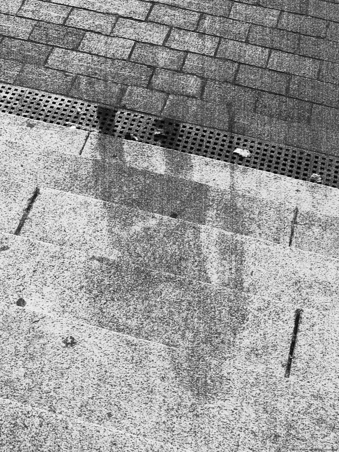 La sombra del residente de Hiroshima con bastón sentado en la escalinata del Banco Sumitomo. La sombra del residente de Hiroshima con bastón sentado en la escalinata del Banco Sumitomo.