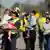 People in yellow vests carry the children away from the bus