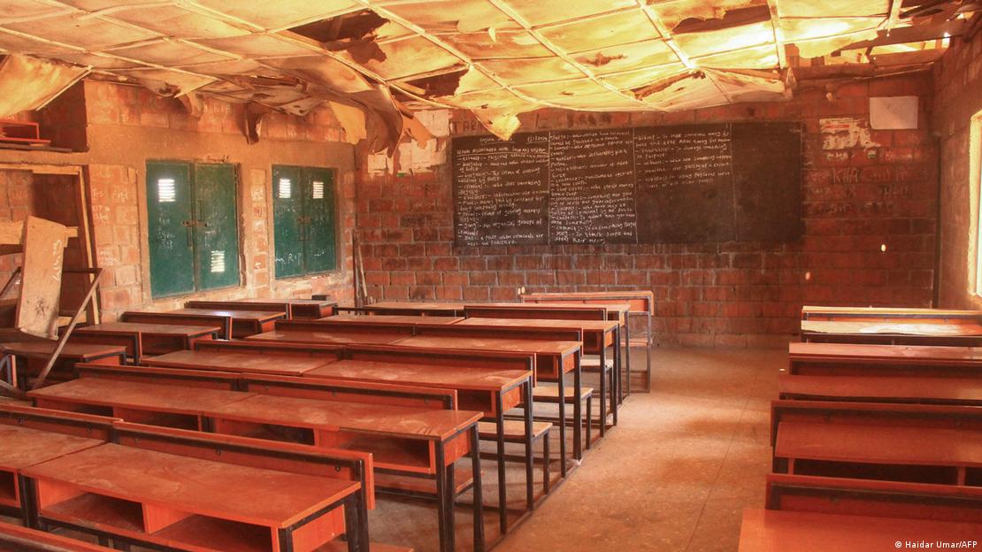 An empty classroom with wooden desks and blackboard 