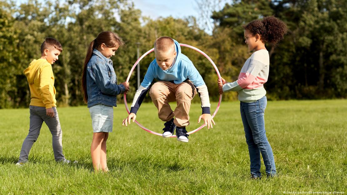 Bir parkta hulahupla oyun oynayan çocuklar