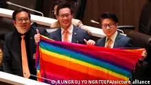 epa11246350 Move Forward Party's Members of Parliament (L-R) Sorrapat Sriprach, Chutchawan Apirukmonkong and Prasit Puttamapadungsak hold a rainbow colored textile to support the LGBTQIA+ during a legislation session held to recognize a marriage equality bill at Parliament in Bangkok, Thailand, 27 March 2024. The House of Representatives passed a historic marriage equality bill to legalize same-sex marriage making Thailand a step closer to being the first Southeast Asian country and the third in Asia to recognize same-sex unions. The bill requires approval from the Senate and royal endorsement before becoming law which is expected before the end of 2024. EPA/RUNGROJ YONGRIT