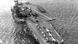 Foto aérea em preto e branco mostra porta-aviões americano em alto-mar. Um modelo similar ao USS Forrestal Aircraft Carrier foi enviado ao Brasil em 1964.