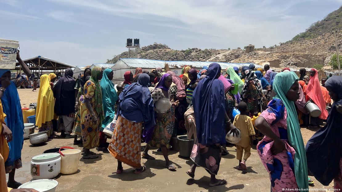 People wait to fill buckets with clean water from a water well at the Gwoza IDP Camp in Borno State, Nigeria. People wait to fill buckets with clean water from a water well at the Gwoza IDP Camp in Borno State, Nigeria.