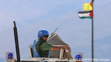 Die palästinensische Flagge und die Flagge der Hisbollah wehen im Wind, während Friedenssoldaten der UNIFIL auf dem Hamames-Hügel in der Region Khiyam im Grenzgebiet zwischen Libanon und Israel patrouillieren. Soldat schaut aus einem Panzer raus.