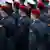 Mladi vojnici u odorama na kojima je na rukavima njemačka zastava s orlom, neki imaju na glavi crvene beretke, neki mornarske bijele kape