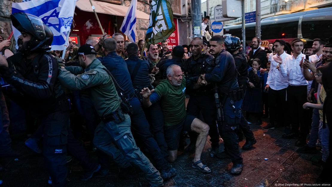 La policía empuja a un miembro del grupo "Hermanos y hermanas en armas", durante una protesta contra el primer ministro Netanyahu en Jerusalén el domingo (31.03.2024)