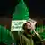 A man smokes in front of a sign that reads 'We don’t want to be criminals' as Germany's friends of cannabis celebrate the part legalization of the drug