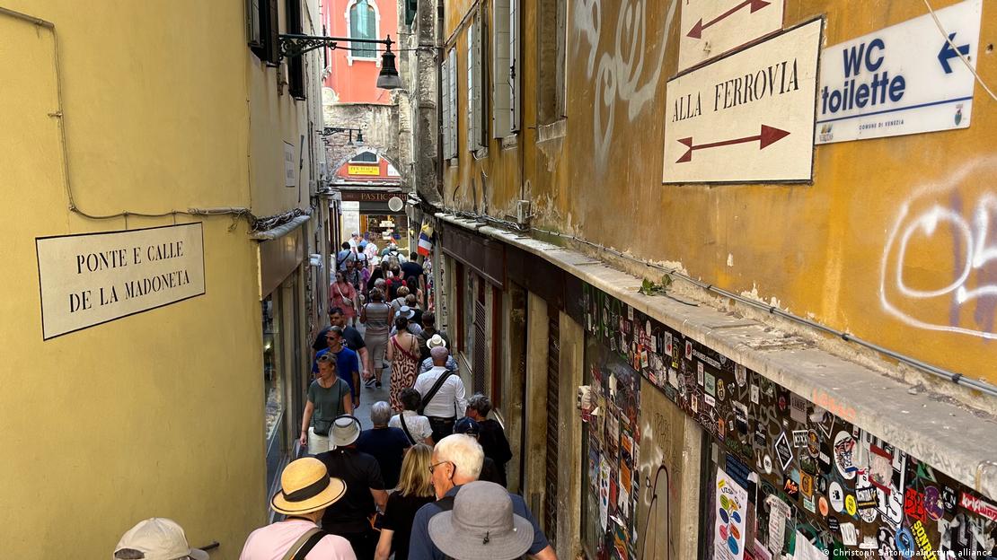 Tourists as seen in a narrow Venice alleyway