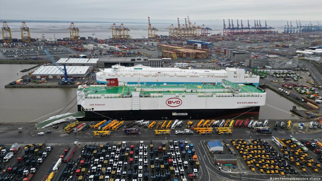 Bremerhaven Limanı'na yanaşan BYD'ye ait dev araç taşıma gemisi ve limandaki alanda yüzlerce otomobil yer alıyor