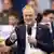 Polish Prime Minister Donald Tusk holds a microphone in one hand and gesticulates with the other as he speaks at a campaign event in the run-up to Sunday's local elections, Krakow, Poland, April 3, 2024