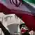 A man with his face painted the colors of the Iranian flag waves an Iranian flag in Teheran 