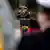 Inka von Puttkamer faz continência ao lado de um púlpito com as cores da bandeira da Alemanha