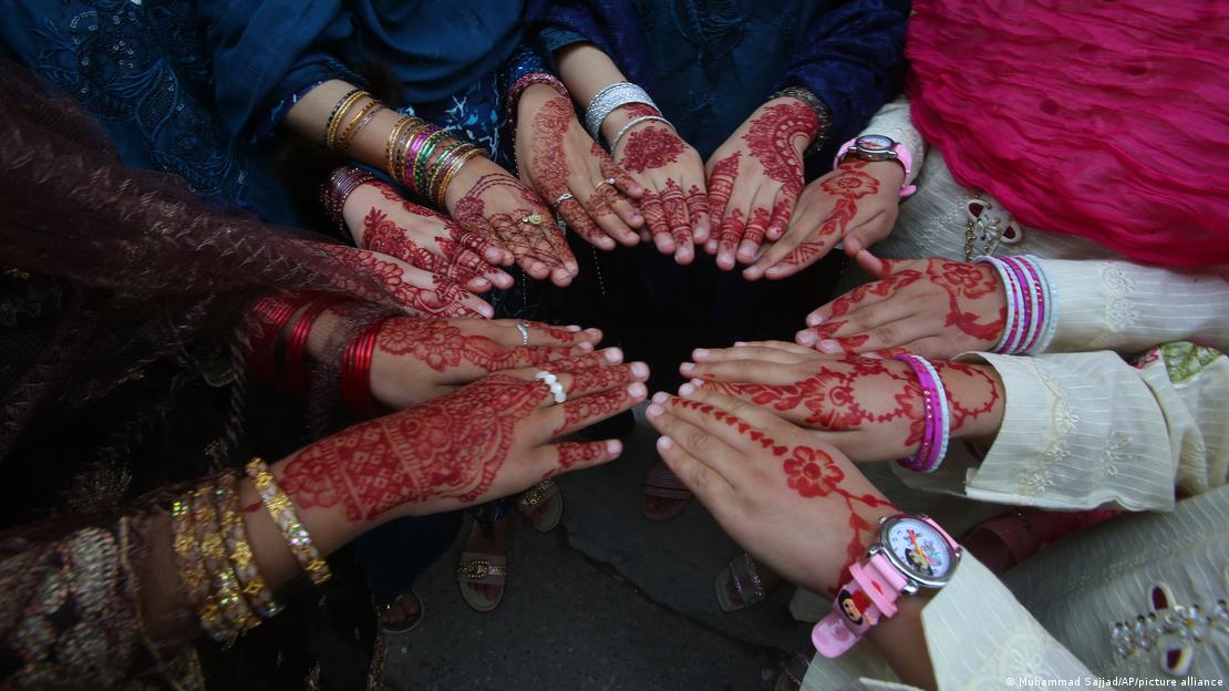 Women in Pakistan display their hands with Henna to mark Eid al-Fitr on April 10