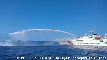 In this photo provided by the Philippine Coast Guard, a Chinese Coast Guard ship, right, uses its water cannons on a Philippine Bureau of Fisheries and Aquatic Resources (BFAR) vessel, not shown, as it approaches Scarborough Shoal in the disputed South China Sea on Saturday Dec. 9, 2023. The Philippines and its treaty ally, the United States, separately condemned a high-seas assault Saturday by the Chinese coast guard and suspected militia ships that repeatedly blasted water cannons to block three Philippine fisheries vessels from a disputed shoal in the South China Sea. (Philippine Coast Guard via AP)