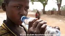 Ein Junge trinkt Wasser in FadaNgourma , Burkina Faso . | Boy is drinking water . FadaNgourma , Burkina Faso . | 20.04.2008 , MODEL RELEASE vorhanden , MODEL RELEASED , Copyright: Ute Grabowsky/ picture alliance/photothek