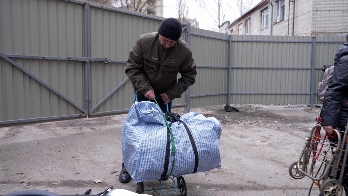 Ein Mann mit einer großen Tasche am Grenzübergang Kolotilowka-Pokrowka