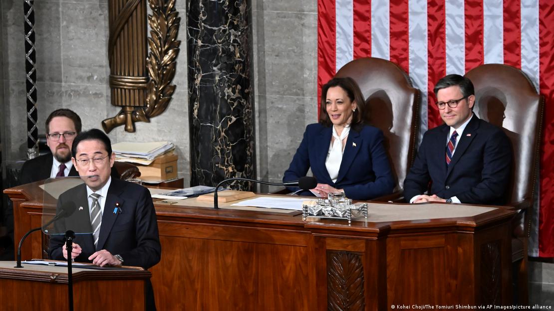 Fumio Kishida speaks with Kamala Harris and Mike Johnson in the background 