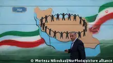 An Iranian man is walking past a mural in downtown Tehran, Iran, on April 13, 2024. The Prime Minister of Israel, Benjamin Netanyahu, is threatening Iran with a counterattack if it directly attacks Israel. (Photo by Morteza Nikoubazl/NurPhoto)