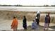 Afghan people wait to cross a flooded area in Spin Boldak district of Kandahar province on April 13, 2024 Afghan people wait to cross a flooded area in Spin Boldak district of Kandahar province on April 13, 2024