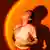 Symbolfoto Junge Frau in Neonbeleuchtung vor orangefarbenem Hintergrundmodell veröffentlicht