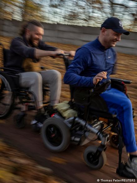 Δύο άνδρες σε αναπηρικά καροτσάκια κινούνται μέσα σε ένα δάσος στην Ουκρανία