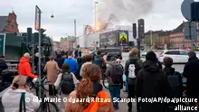 16.04.2024, Dänemark, Kopenhagen: Menschen beobachte, wie Feuer und Rauch aus der Alten Börse, Boersen bei einem Brand in Kopenhagen aufsteigen. Foto: Ida Marie Odgaard/Ritzau Scanpix Foto/AP +++ dpa-Bildfunk +++