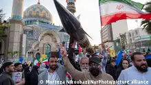 Unidentified men are carrying a model of Iran's first-ever hypersonic missile, Fattah, past a mosque during a gathering to celebrate the IRGC UAV and missile attack against Israel, in Tehran, Iran, on April 15, 2024. Iran launched dozens of Unmanned Aerial Vehicles (UAVs) and missiles against Israel on April 13th in response to the Israeli attack on its Consulate in Damascus. (Photo by Morteza Nikoubazl/NurPhoto)