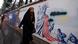 An Iranian veiled woman in a black chador walks past a mural painting depicting the State of Liberty in Washington DC. An Iranian veiled woman in a black chador walks past a mural painting depicting the State of Liberty in Washington DC.